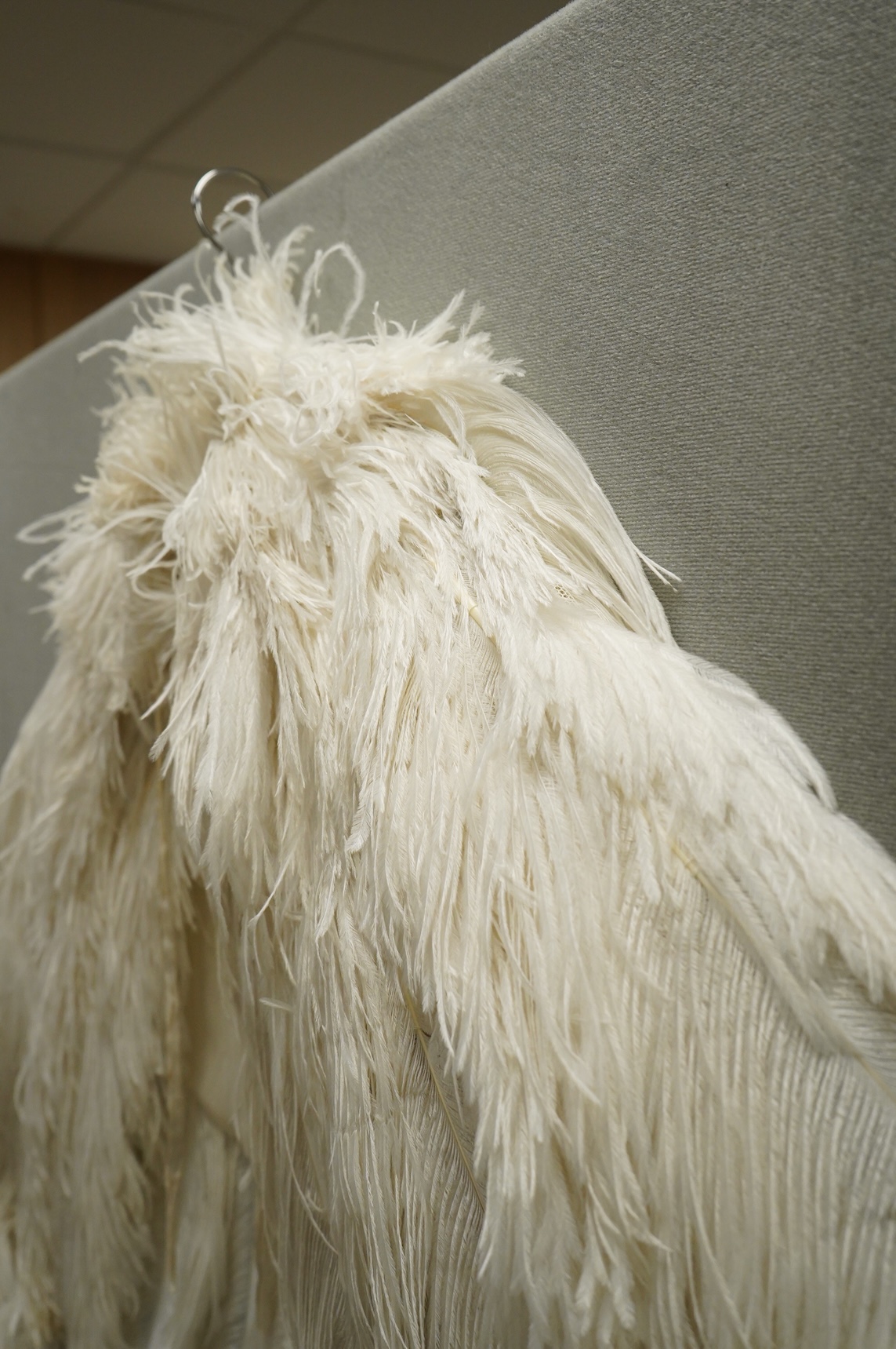 A 1930’s white Ostrich feather evening cape, with small feather stand up collar half lined in georgette.667cm long from top of collar to base. Condition - good - may need professional cleaning.